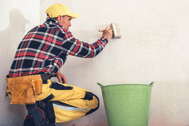 Professional Painting Contractors in Norwalk, CT, are priming walls with large brushes.