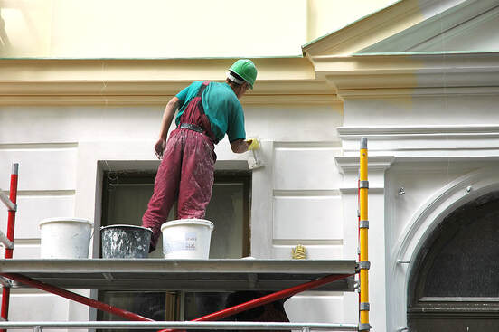A painter works on the third story of a house in Norwalk, CT.