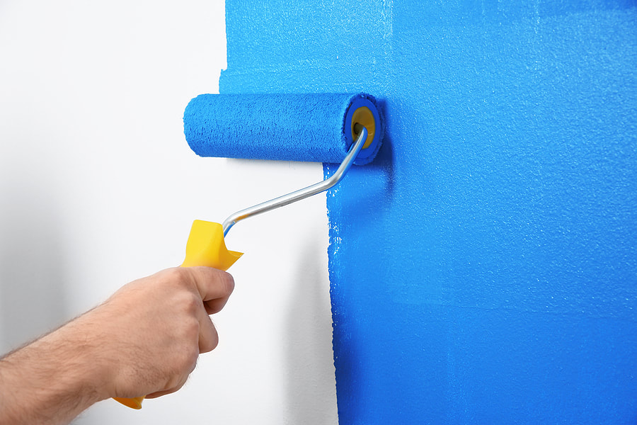 During an interior renovation project in Norwalk, CT, a worker dyes a white wall blue.